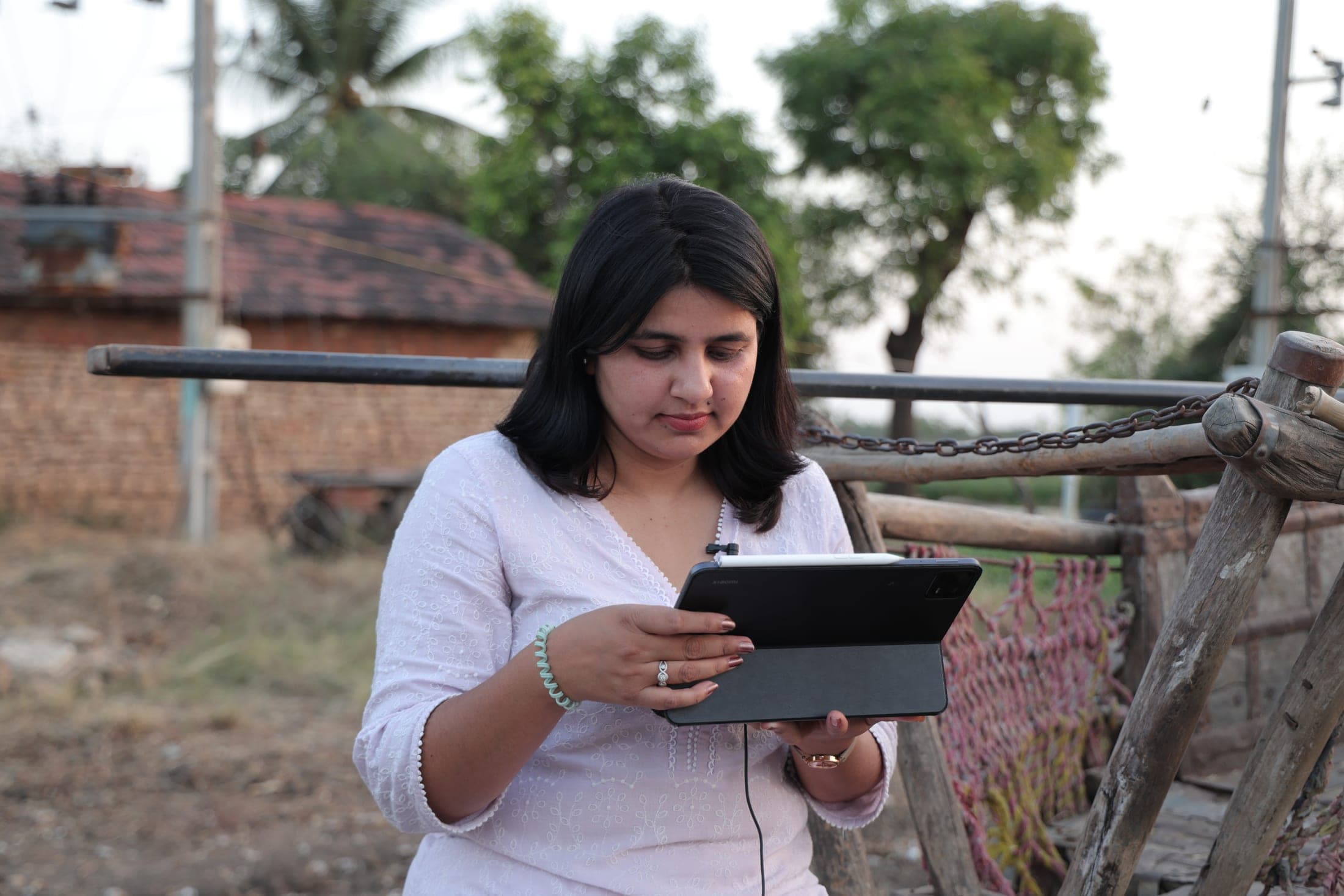 A team member records field data on a tablet in a village